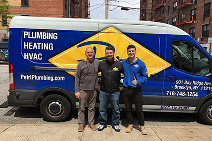 plumbers and hvac technicians in front of pluming van in brooklyn or queens, NY