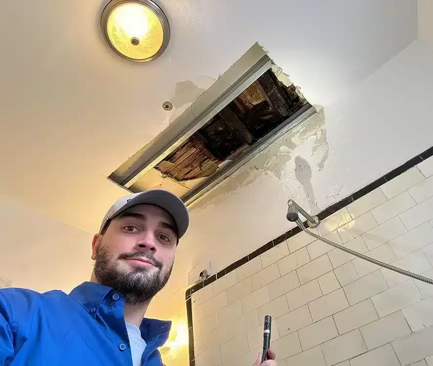 A Petri technician inspecting a leak in a bathroom ceiling in Brooklyn, NY.