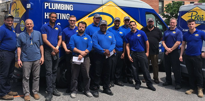 technicians standing in front of plumbing and HVAC van in Queens, NY