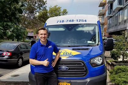 technicians standing in front of plumbing and HVAC van in Queens, NY