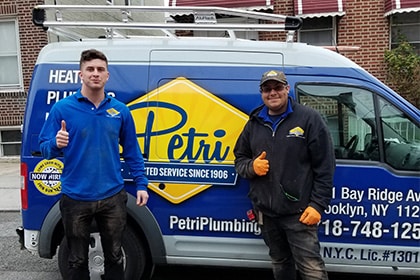 plumbers and hvac technicians in front of plumbing van in brooklyn or queens, NY