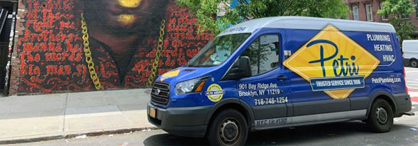 technicians standing in front of plumbing and HVAC van in Queens, NY