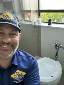 Petri Technician smiling after completing a bathroom plumbing service at a home in Brooklyn, NY.